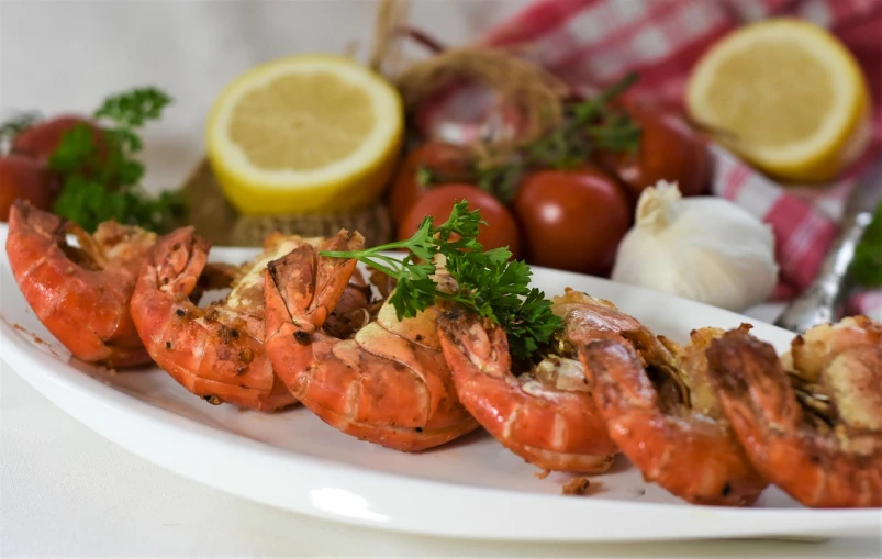 a close up of a plate of food on a table, a picture, by Aleksander Gierymski, pixabay, hurufiyya, shrimp, 💣 💥, grill, 3/4 side view