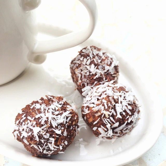 three chocolate donuts on a plate next to a cup of coffee, inspired by Georg Friedrich Schmidt, balls of rice, coconuts, fitness, malaysian