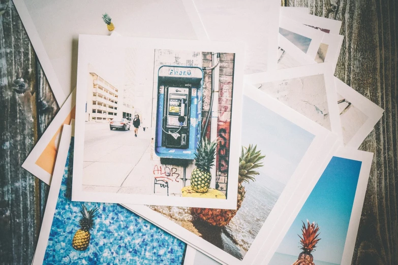 a pile of postcards sitting on top of a table, a polaroid photo, tropical undertones, blue and yellow color theme, half image, phone photo