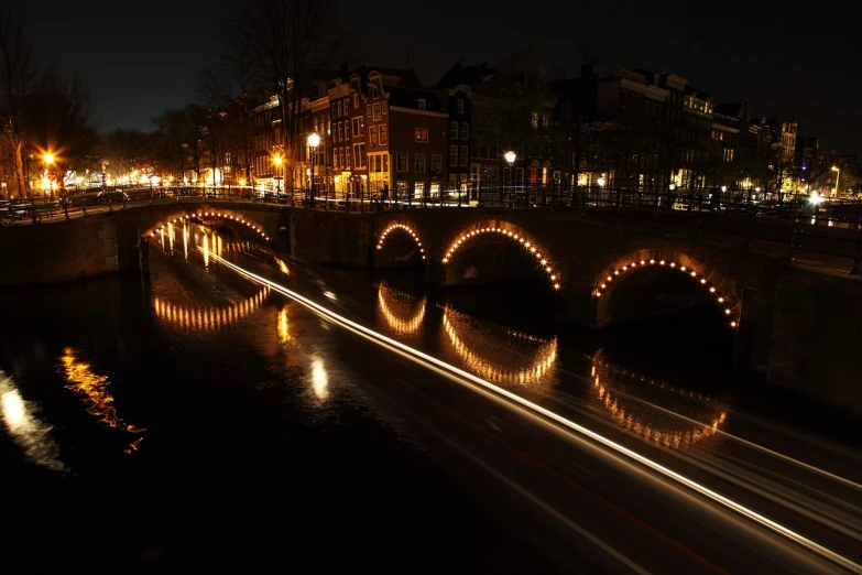 a bridge over a body of water at night, a picture, by Jacob van Utrecht, wikipedia, twisting streets, romantic light, side