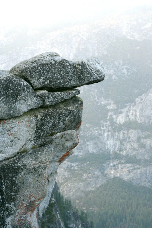 a person standing on top of a large rock, by Erwin Bowien, yosemite valley, pareidolia, telephoto shot, side of head