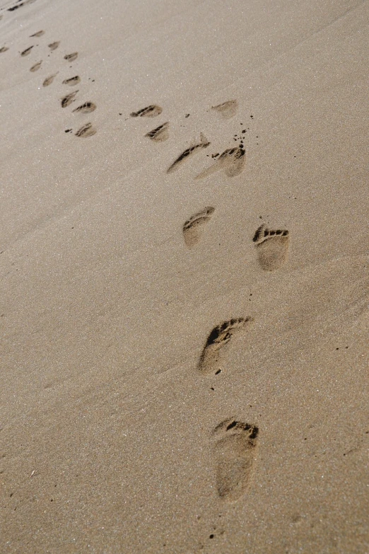 a couple of footprints that are in the sand, inspired by Henri Michaux, taken with a pentax k1000, high res photo, portait photo, coast