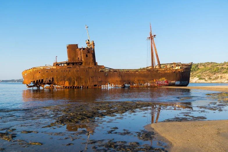 a rusted ship sitting on top of a body of water, a portrait, by Edwin Georgi, shutterstock, beached submarine, alexandros pyromallis, three - quarter view, ultra wide-shot