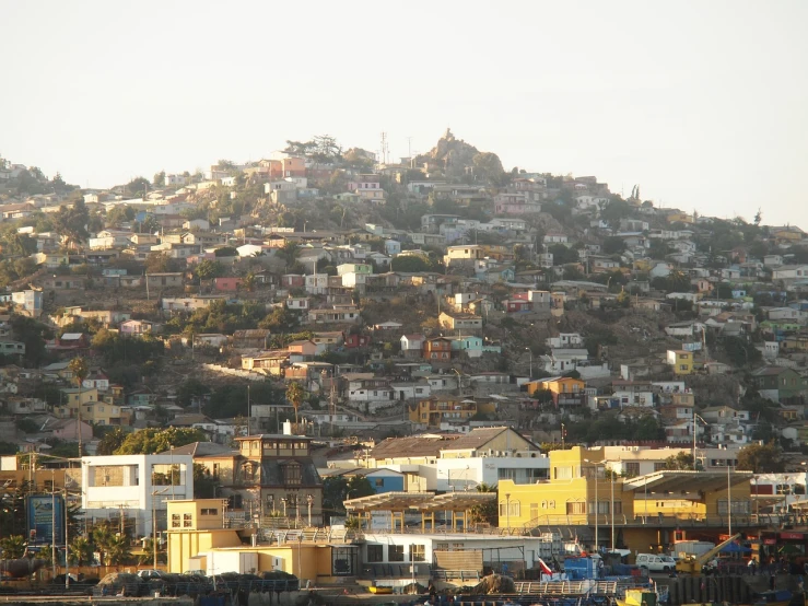 a hill covered in lots of houses next to a body of water, flickr, dau-al-set, dakar, chile, morning detail, beautiful late afternoon