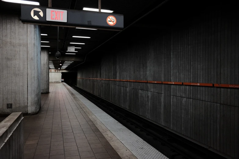 a train pulling into a train station next to a platform, by Andrew Domachowski, flickr, postminimalism, entrance to a dark tunnel, seattle, orange line, high detail photo of a deserted