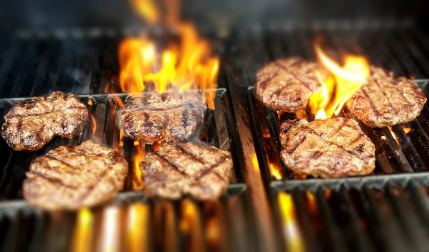 hamburgers cooking on a grill with flames in the background, a picture, pexels, 🕹️ 😎 🔫 🤖 🚬, carnivore, avatar image, detailed zoom photo