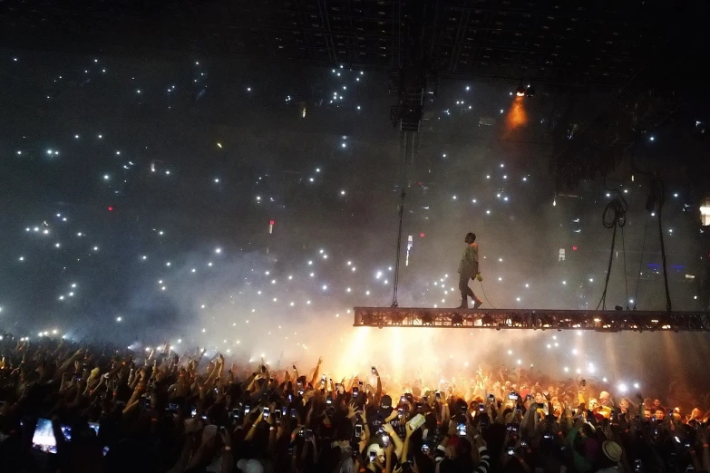 a man standing on a platform in front of a crowd, a picture, yeezy, lots of lights, floating dust, selfie