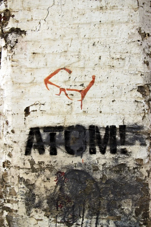 a brick wall with the word atomic painted on it, a poster, graffiti, wearing red tainted glasses, high res photo