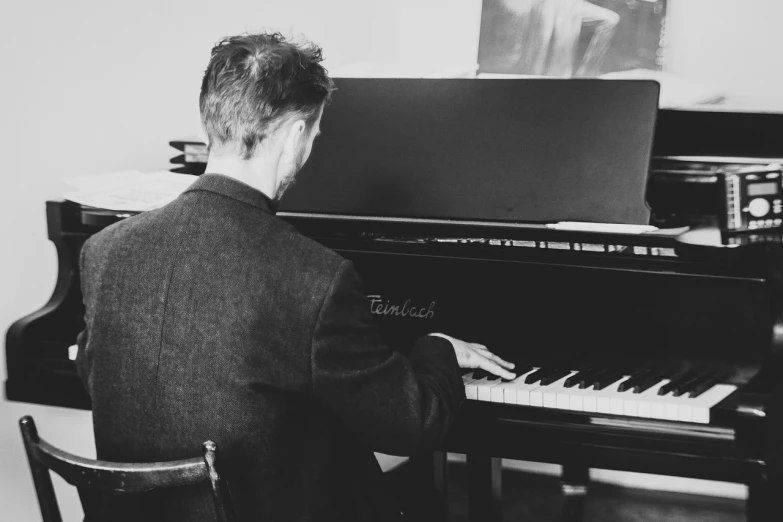 a black and white photo of a man playing a piano, unsplash, fine art, paul davey, colour corrected, tom hiddleston, high key