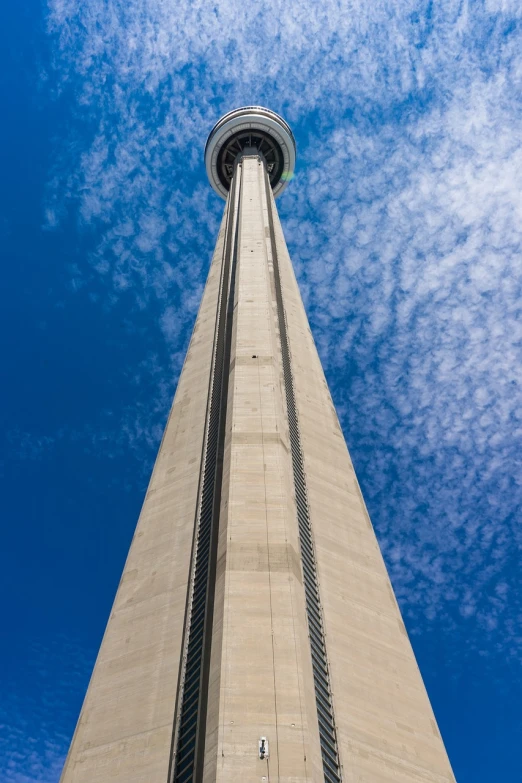 a tall tower with a blue sky in the background, by Brigette Barrager, shutterstock, cn tower, extremely wide angle shot, super long shot, 1 8 3 4
