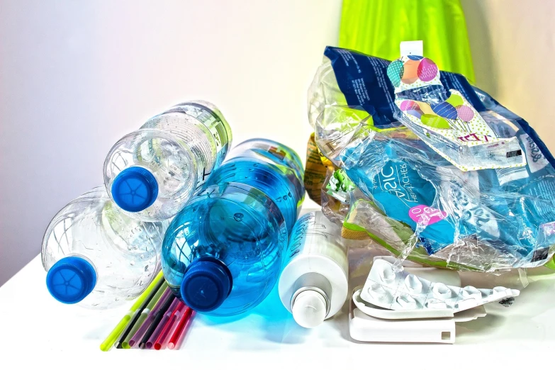 a bunch of water bottles sitting on top of a table, a picture, plasticien, bags, on a white background, blue and green colours, trash