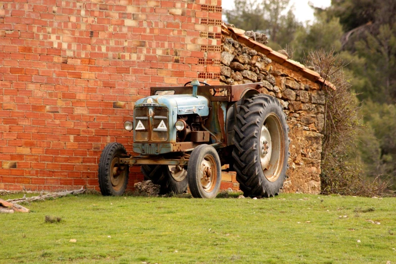 a tractor parked in front of a brick building, flickr, in spain, (((rusty))), smurf, farmland