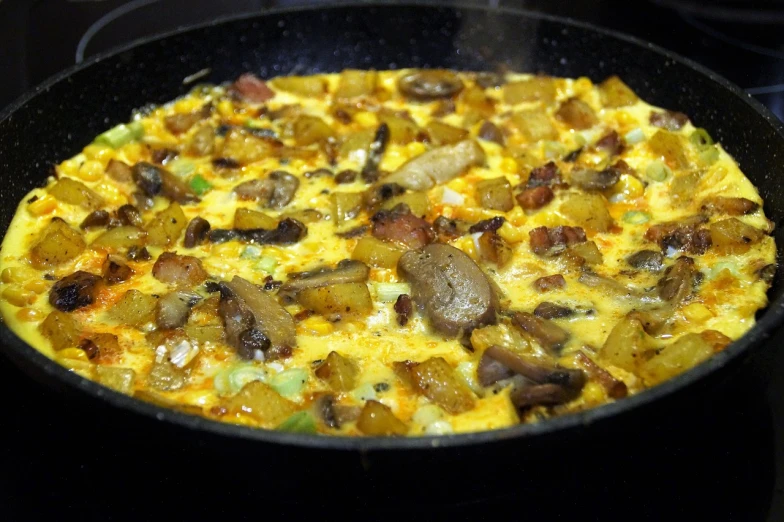 a close up of a pan of food on a stove, inspired by Géza Dósa, flickr, hearty breakfast, brocade, angled shot, reverse