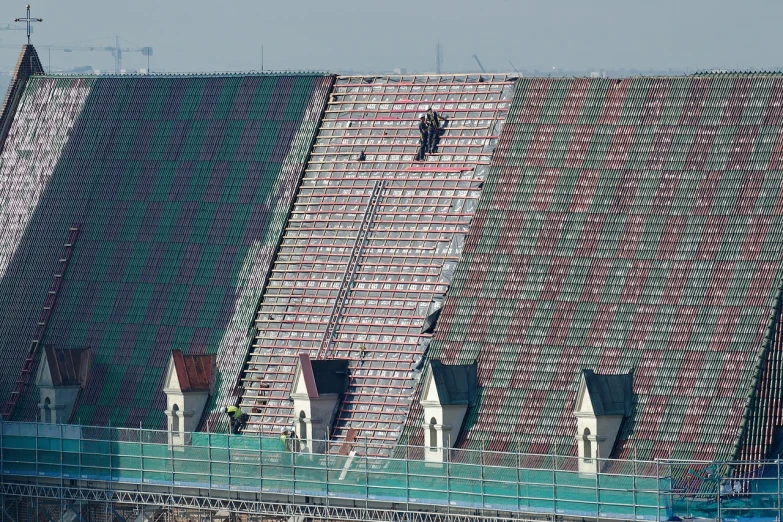 a group of people standing on top of a roof, a mosaic, by Attila Meszlenyi, shutterstock, football hooligans, under repairs, maintenance photo