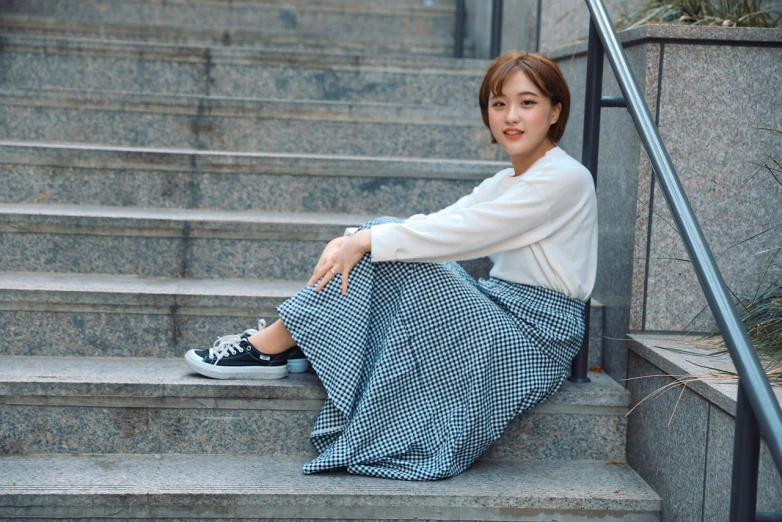 a woman sitting on the steps of a building, a picture, inspired by Kim Jeong-hui, instagram, on a checkered floor, beautiful young korean woman, fullbody photo, long skirt