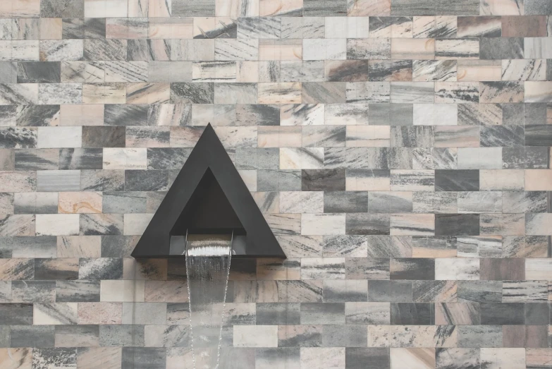 a white toilet sitting in front of a tiled wall, a mosaic, inspired by Peter Zumthor, shutterstock, pyramid head, fountain, tonal colors outdoor, black stone