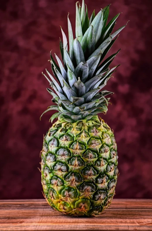 a pineapple sitting on top of a wooden table, a portrait, by Arnie Swekel, shutterstock contest winner, hyperrealism, in red background, stock photo, tropical fruit, heavily ornamental