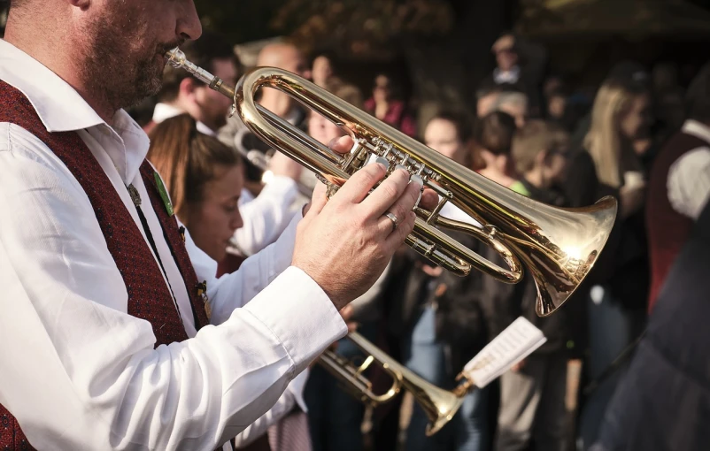 a man playing a trumpet in front of a crowd, by Thomas Häfner, pexels, figuration libre, closeup - view, fall season, many small details, white horns