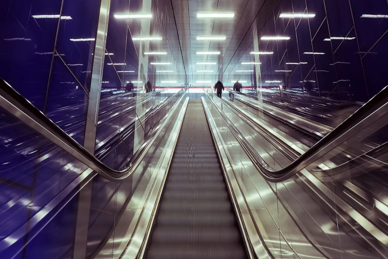 a couple of people riding down an escalator, a picture, by Matthias Weischer, flickr, futurism, post processed denoised, liminal space in outer space!!!, glass and lights, ultra wide