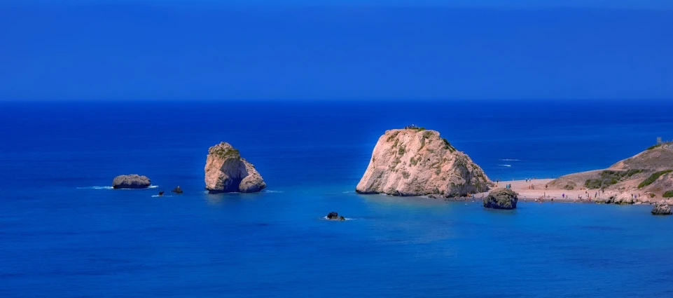 two large rocks in the middle of a body of water, by Michalis Oikonomou, shutterstock, royal-blue, aphrodite, viewed from very far away, wallpaper - 1 0 2 4