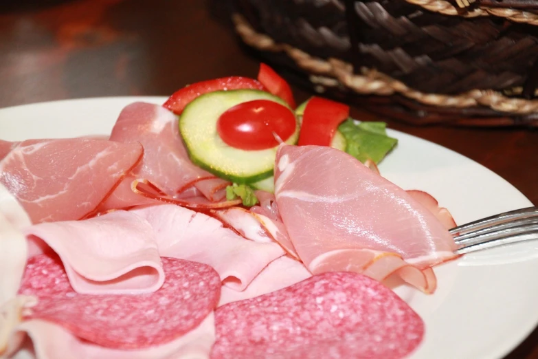a white plate topped with meat and veggies, by Josef Navrátil, salami, close-up product photo