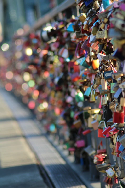 a bunch of locks attached to a fence, a tilt shift photo, happening, magic crystal bridge colorfully, movie screencap, kreuzberg, in tokio