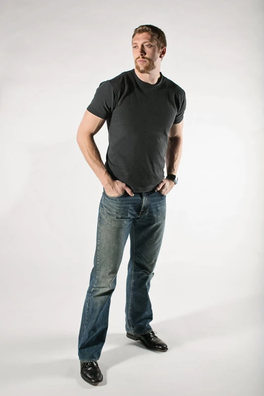 a man standing with his hands in his pockets, by Joe Stefanelli, jeans and t shirt, high res photo, athletic man in his 30s, product introduction photo