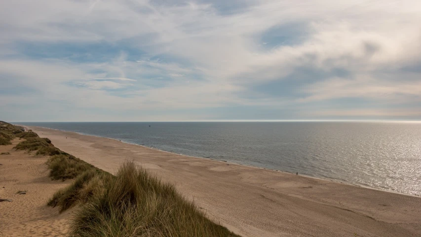 a large body of water sitting on top of a sandy beach, a photo, by Jesper Knudsen, iso 1 0 0 wide view, eldenring, coastline, distant view