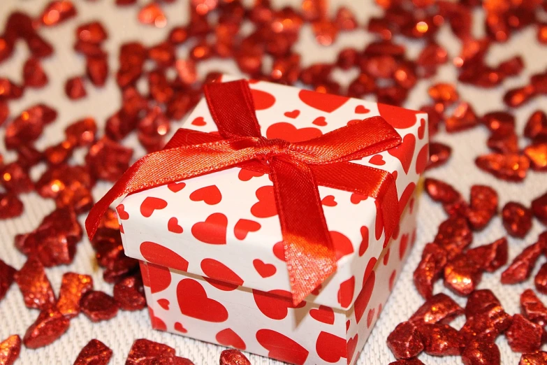 a red and white box with hearts on it, a picture, pixabay, wrapped, sandra chevier, covered, twas brillig