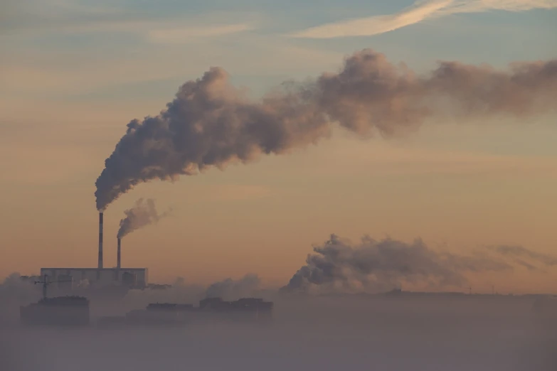 a factory with a lot of smoke coming out of it, by Stefan Gierowski, shutterstock, foggy at dawn, freezing, telephoto shot, stock photo