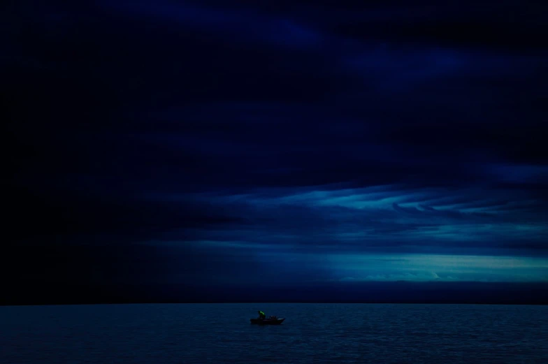 a small boat floating on top of a large body of water, a picture, by Tadashige Ono, extremely moody blue lighting, photography alexey kurylev, michael page, overcast dusk