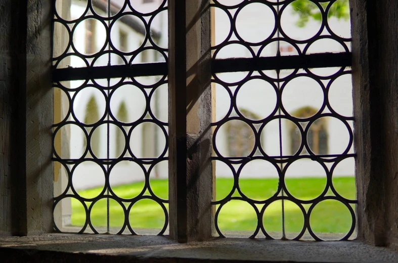 a close up of a window with a building in the background, inspired by Ambrosius Benson, flickr, circles, stood in a cell, high dof, shady