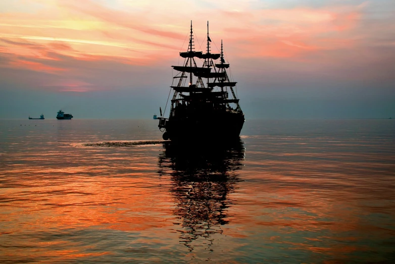 a large boat floating on top of a body of water, a photo, by Tom Carapic, shutterstock, romanticism, pirate setting, black silhouette, nice colors, full frame shot