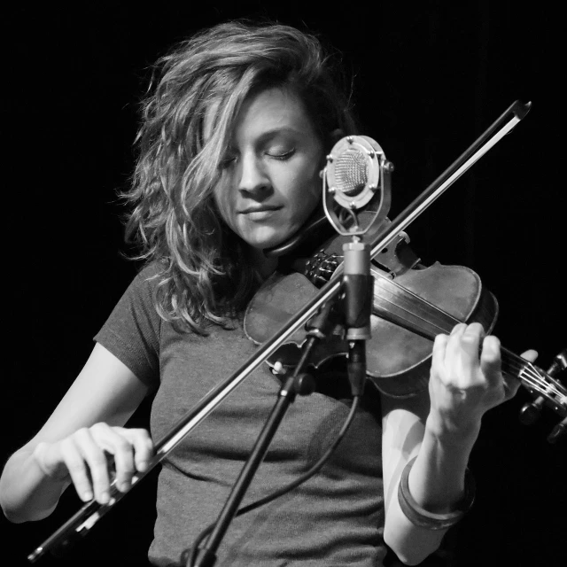 a black and white photo of a woman playing a violin, a portrait, antipodeans, performing on stage, katey truhn, minn, clover