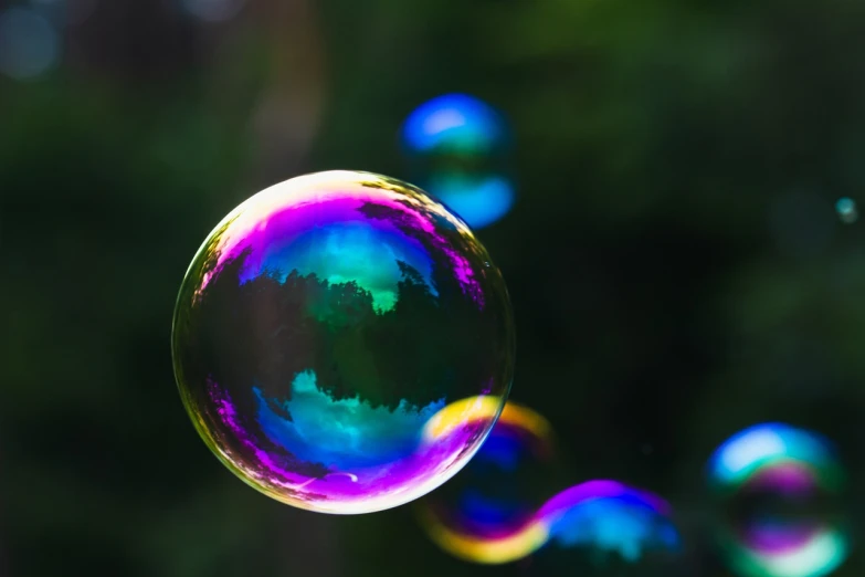 a group of soap bubbles floating in the air, a picture, by Jan Rustem, shutterstock, tilt shift mirror background, viewed in profile from far away, vibrant iridescent, tamborine
