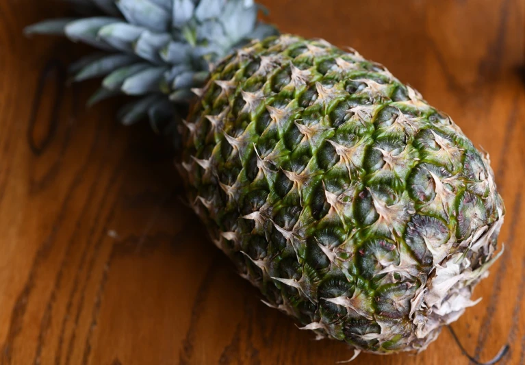 a pineapple sitting on top of a wooden table, sōsaku hanga, very sharp photo