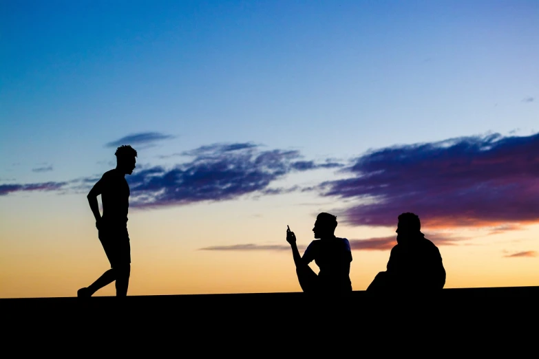 a couple of people standing on top of a hill, a picture, figuration libre, relaxing on the beach at sunset, trio, talking, photo taken at night