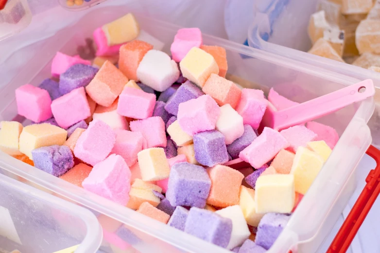 a plastic container filled with lots of different colored marshmallows, a pastel, closeup photo, close-up product photo, blocks, foamy bubbles