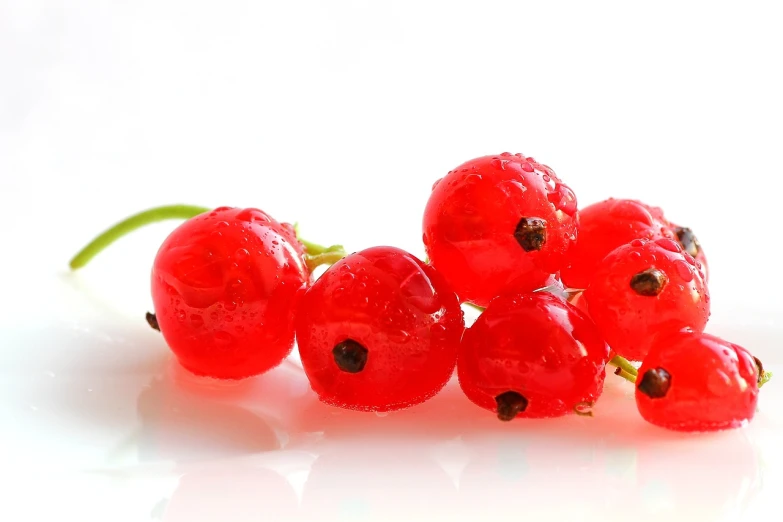 a bunch of red berries sitting on top of a white surface, romanticism, crisp hd image, jelly, 1/320, rocket