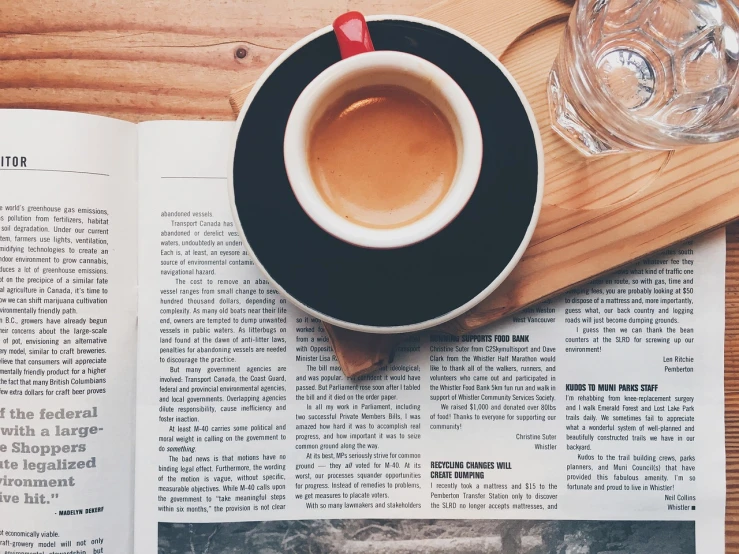 a cup of coffee sitting on top of a wooden table, unsplash, private press, newspaper style, one contrasting small feature, hero shot, hd wallpaper