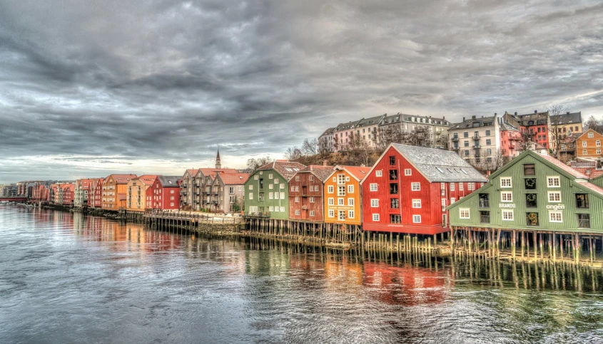 a row of colorful houses next to a body of water, by Sven Nordqvist, fur hdr, viking style, muted and dull colors, kieth thomsen