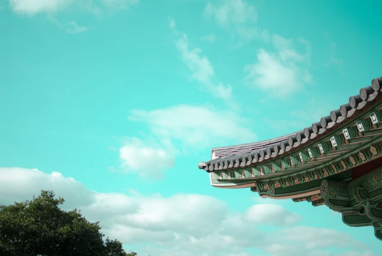 the roof of a building with a blue sky in the background, a tilt shift photo, inspired by Kim Hong-do, aestheticism, palace floating in the sky, teal sky, low angle photo, over-shoulder shot