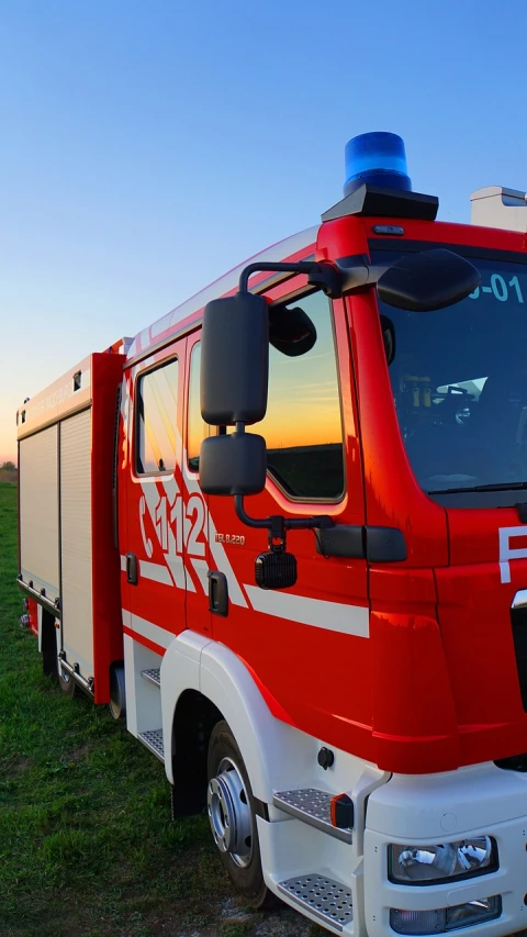 a red and white fire truck parked in a field, a picture, by Robert Zünd, shutterstock, figuration libre, vibrant backlit, hoog detail, fire reflection, full device
