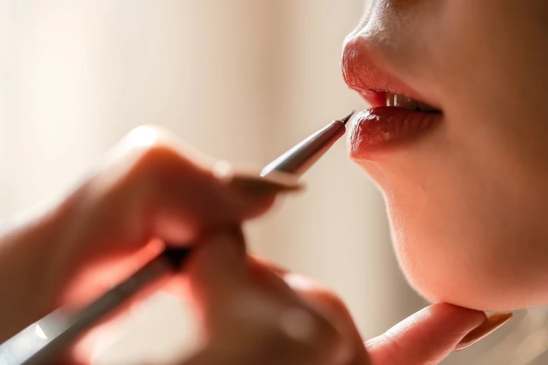 a woman is putting lipstick on her lips, shutterstock, hyperrealism, professional closeup photo, soft light from the side, [ [ hyperrealistic ] ], brushes her teeth