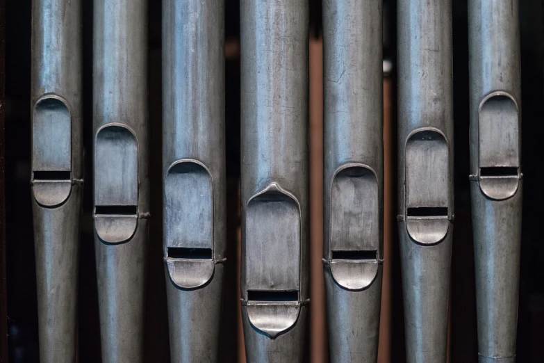 a group of pipes sitting next to each other, an album cover, by Frederik Vermehren, shutterstock, folk art, pipe organ, grey metal body, symmetrical faces, stock photo