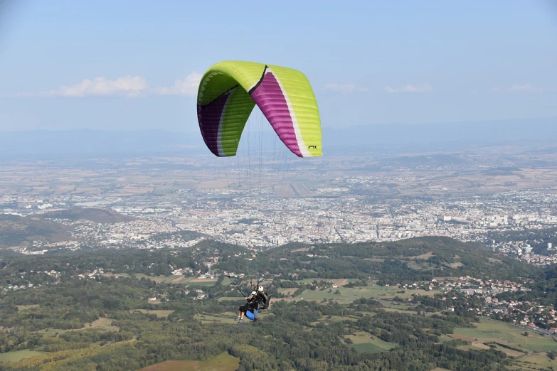 a person that is in the air with a parachute, a picture, shutterstock, figuration libre, green and purple, traveling in france, 2 0 2 2 photo, kawasaki