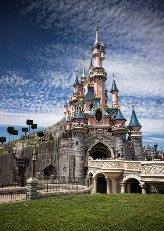 a castle sitting on top of a lush green field, inspired by disney, art nouveau, disneyland as backdrop, carousel, france, epic and stunning