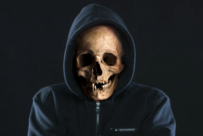 a man in a hoodie with a skull on his face, a portrait, shutterstock, he is wearing a black t-shirt, humanoid face, zippered opening in skull, facebook profile picture