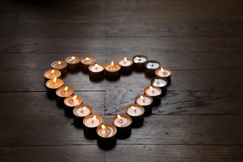 a heart made out of candles on a wooden floor, romanticism, group photo, barnet, high res photo, caramel
