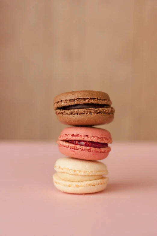 three macarons stacked on top of each other, by François Girardon, unsplash, brown and magenta color scheme, soft red tone colors, portrait 4 / 3, 2 0 1 0 s